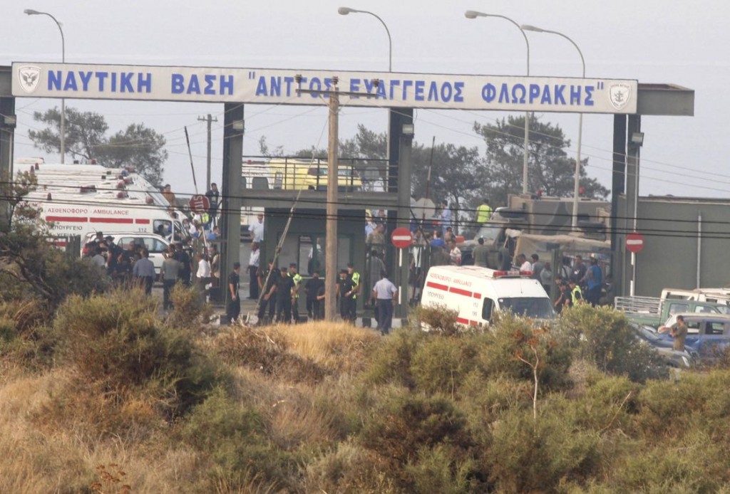 Emergency personnel are seen at the entrance of a military base where a large explosion occurred in southern Cyprus