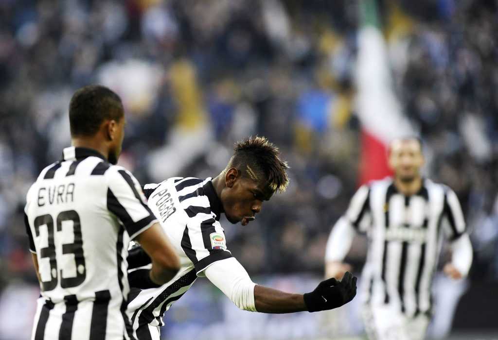 Juventus' Paul Pogba celebrates with his team mate Patrice Evra after scoring against Chievo Verona during their Italian Serie A soccer match in Turin