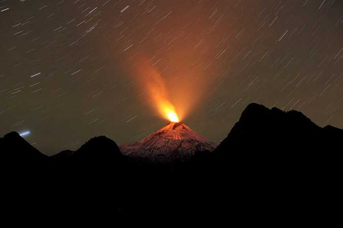 Smoke and lava spew from the Villarrica volcano, as seen from Pucon town in the south of Santiago, April 20, 2015. Authorities have restricted access to the area within 5 kilometres (3 miles) of the crater and have put the area under an orange alert due to the volcano's heightened unrest and increased likelihood of eruption. Picture taken April 20, 2015. REUTERS/Cristobal Saavedra TPX IMAGES OF THE DAY